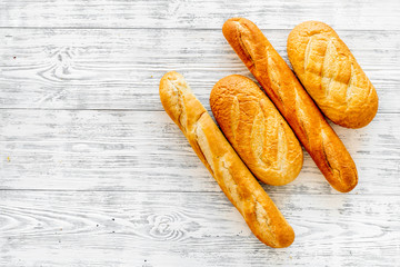 Loaf of white bread and baguette on white wooden background top view space for text
