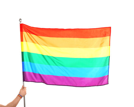 Gay man holding rainbow LGBT flag on white background