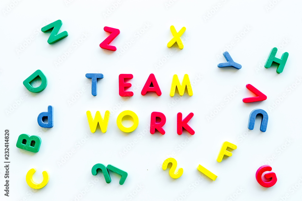 Poster teamwork training concept. text teamwork lined with colored letters in frame of toy letters on white