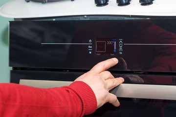 The male salesman shows the functions of controlling the gas stove.