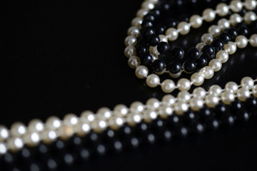 Black and white beads necklace on a dark background close up