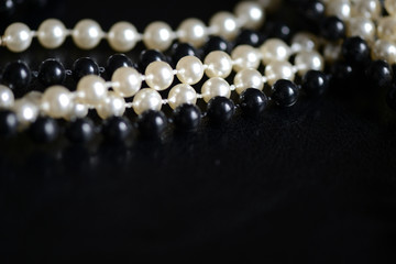Black and white beads necklace on a dark background close up