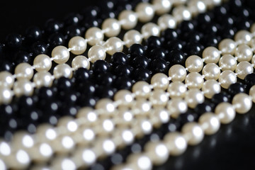Black and white beads necklace on a dark background close up