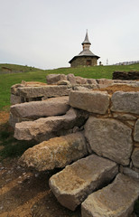 Small stone church build near ancient remains rocks of an old fortress near O