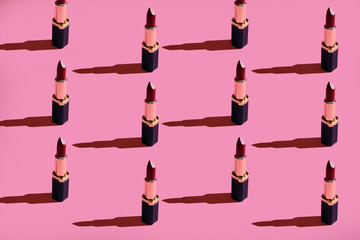 a lot of lipstick on a pink background hard light