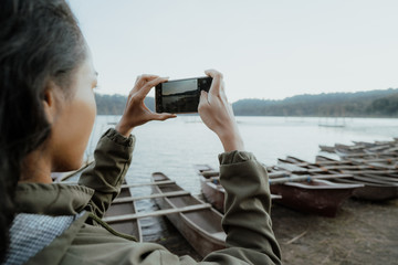 woman taking picture of beautiful lake nature