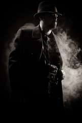 Fototapeta na wymiar man in a black hat and coat on a dark background, Studio photo