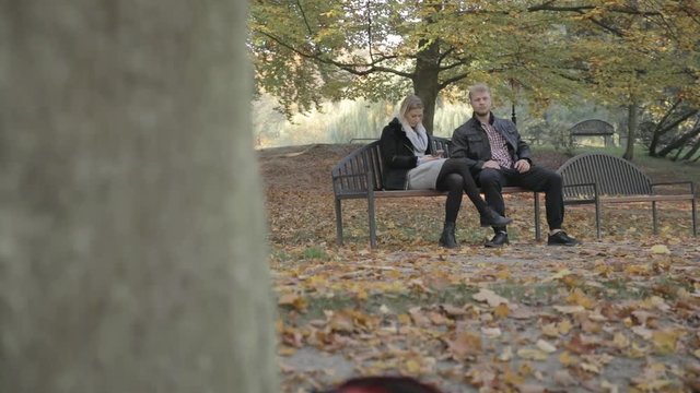 Point of view of a creepy voyeur getting caught spying on a couple in a park and gets chased off