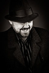 man in a black hat and coat on a dark background, Studio photo