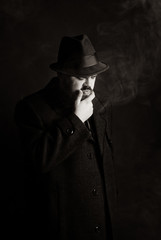 man in a black hat and coat on a dark background, Studio photo