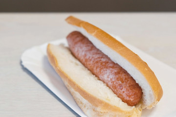Hotdog on the table in cafe in door.