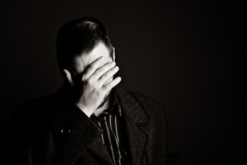 portrait of a man in a black coat on a dark background, Studio photo