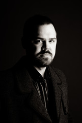 portrait of a man in a black coat on a dark background, Studio photo