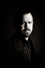 portrait of a man in a black coat on a dark background, Studio photo