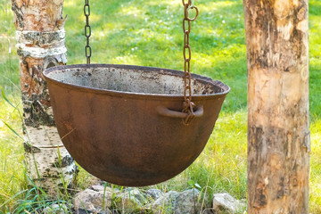 Cauldron, pot for cooking hanging on chains over the fire.