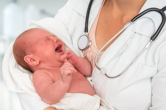 Pediatrician Doctor Is Holding Newborn Baby In Arms