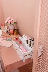 Working corner in pink color scheme with terrazzo drawer ,bouquet flower,gold vase,pink candle and golden frame on pink painted wall / cozy interior concept / fashion design / blogger