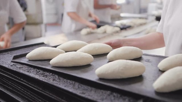 Baker's hands make bread on the table out of pieces of dough. Baking, tradition. Bread industry.