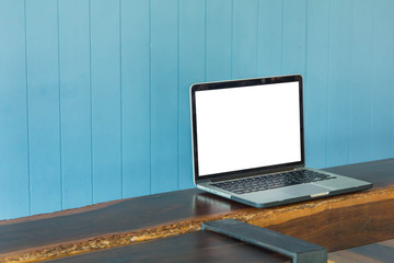 Laptop place on the table for find information on working for business with vintage blue backdrops in coffee shop