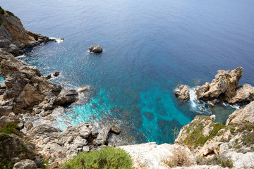 Fototapeta na wymiar Beautiful seascape with turquoise water, cliffs and the sea. Sunny warm tropical day. Background for travel on the Mediterranean. Greece. Europe
