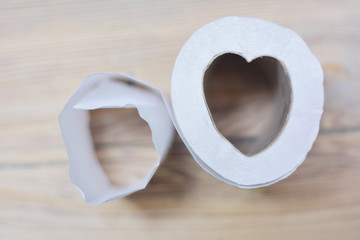 Toilet paper in the form of heart. Wooden background.