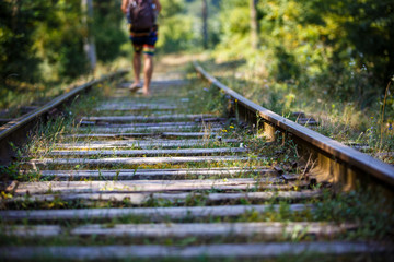 Walk on the railway in the summer, sleepers overgrown with grass. Railway tracks go into the...