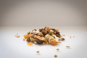 Pile of trail mix and nuts on a whie background. Isolated copyspace.