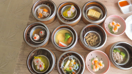 close up of set steamed dim sum dumplings in basket, chinese traditional food