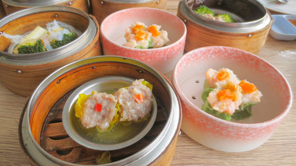 close up of set steamed dim sum dumplings in basket, chinese traditional food
