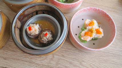 close up of set steamed dim sum dumplings in basket, chinese traditional food