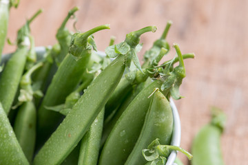 Pod of green pea , green peas, on wood background