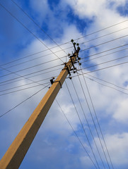 Electric pole with wires against the sky