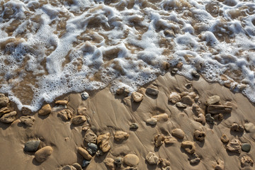 Closeup of waves on the sand and rocks at Cotters Beach, Wilsons Promotory, Victoria, Australia.