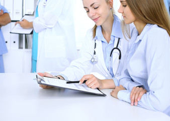 Fototapeta premium Doctor and patient are discussing something, just hands at the table. Medicine concept