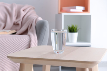 Glass of fresh water on wooden table indoors