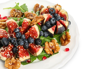 Delicious fresh salad with walnuts on plate, isolated on white
