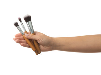 Woman holding makeup brushes on white background