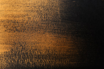Strokes of gold paint on dark background
