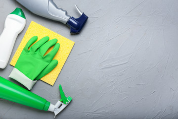 Flat lay composition with cleaning supplies on grey background