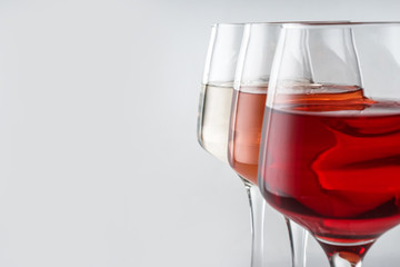 Glasses of tasty wine on white background, closeup