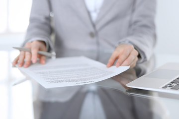 Close-up of female hands with pen over document,  business concept. Lawyer or business woman at work in office