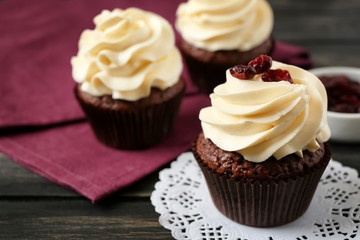 Tasty chocolate cupcake on wooden table