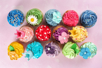 Tasty cupcakes on color background