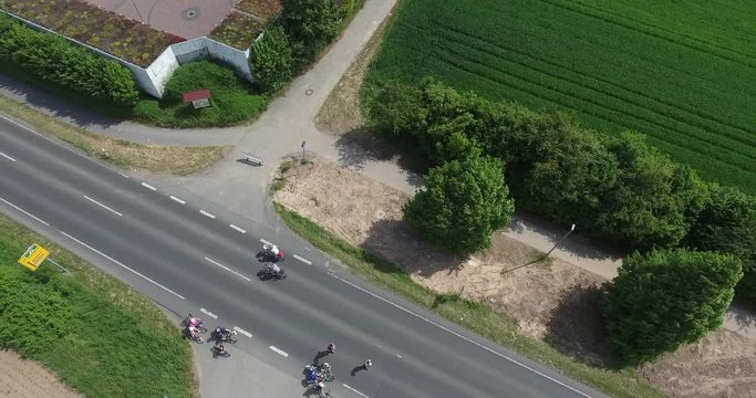 Drohnenaufstieg - autofreie Landstraße mit Radfahrern und Blick nach unten