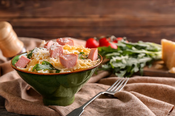 Delicious pasta with sausage in bowl on table