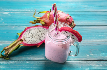 Mason jar of smoothie with dragon fruit on wooden table