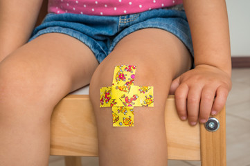 Child with adhesive bandage on knee