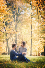 beautiful couple is sitting on the meadow