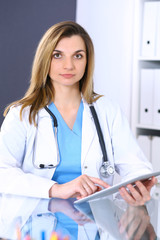 Woman doctor at work in hospital office. Portrait of female physician. Medicine and health care concept