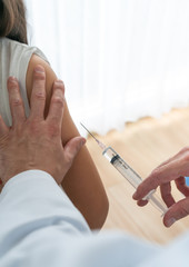 Doctor using syringe to give in jection to patient